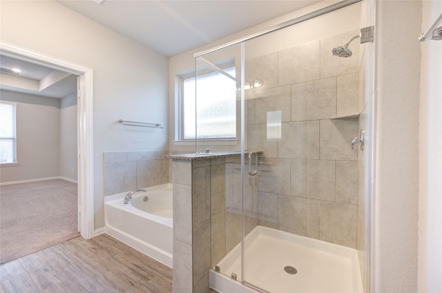 bathroom with wood-type flooring and separate shower and tub