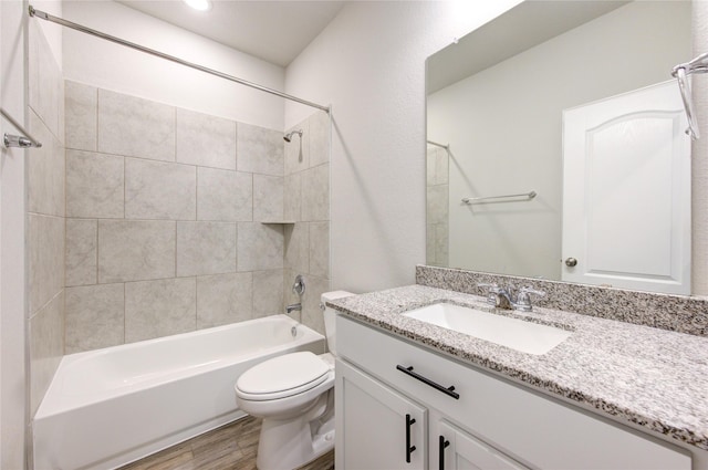 full bathroom featuring tiled shower / bath, vanity, toilet, and wood-type flooring