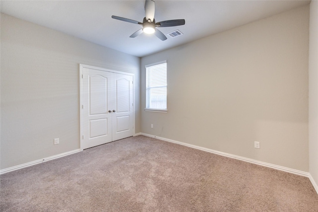 unfurnished bedroom featuring carpet flooring, ceiling fan, and a closet