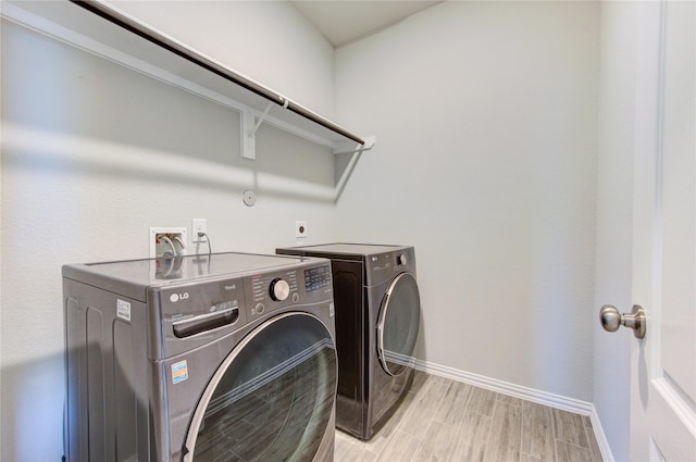 laundry area featuring washer and dryer and light wood-type flooring