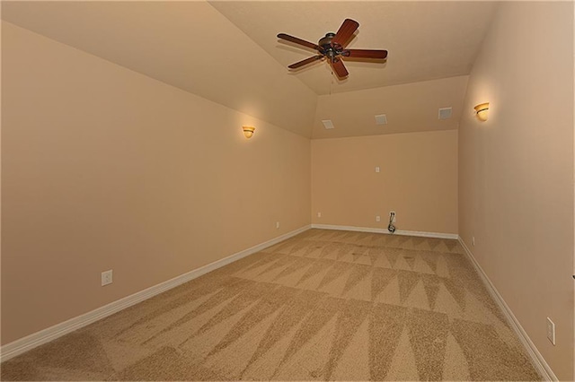 carpeted spare room featuring lofted ceiling and ceiling fan