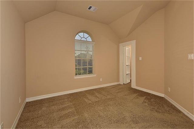 spare room featuring vaulted ceiling and light carpet