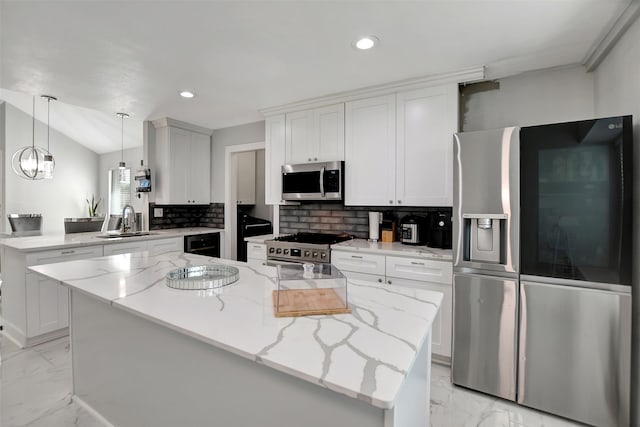 kitchen featuring light stone counters, stainless steel appliances, sink, and white cabinets