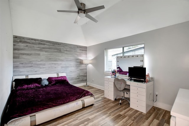 bedroom with ceiling fan, lofted ceiling, and light hardwood / wood-style floors