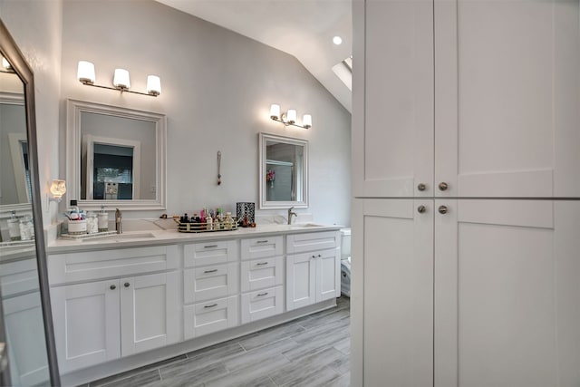 bathroom with lofted ceiling, vanity, and toilet