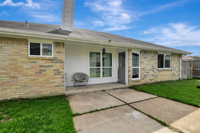 rear view of property with a yard and a patio area