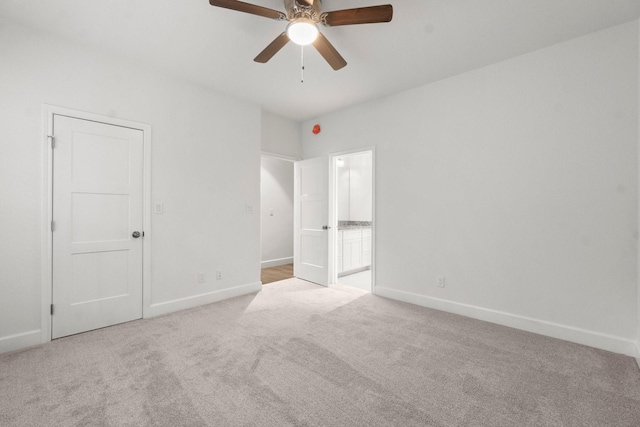 unfurnished bedroom with connected bathroom, light carpet, and ceiling fan