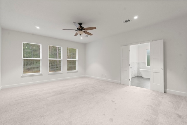 carpeted spare room featuring ceiling fan