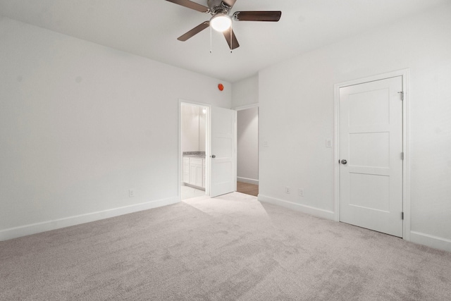 unfurnished bedroom featuring ceiling fan, ensuite bath, and light carpet