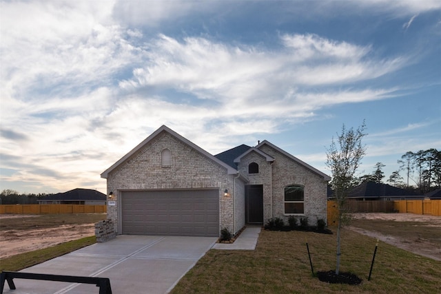 french country home featuring a garage and a yard