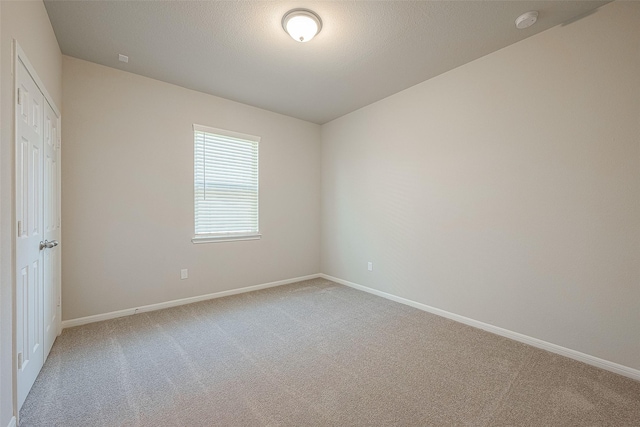 unfurnished room with carpet floors and a textured ceiling