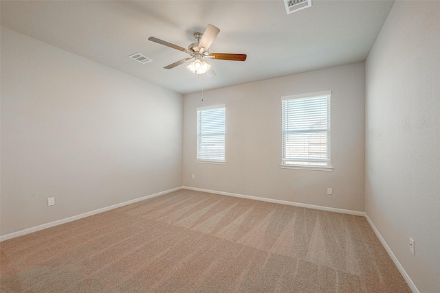 carpeted spare room featuring ceiling fan