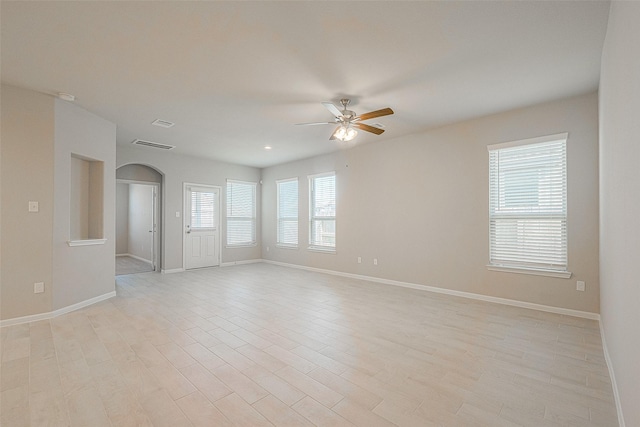 empty room with ceiling fan and light hardwood / wood-style flooring