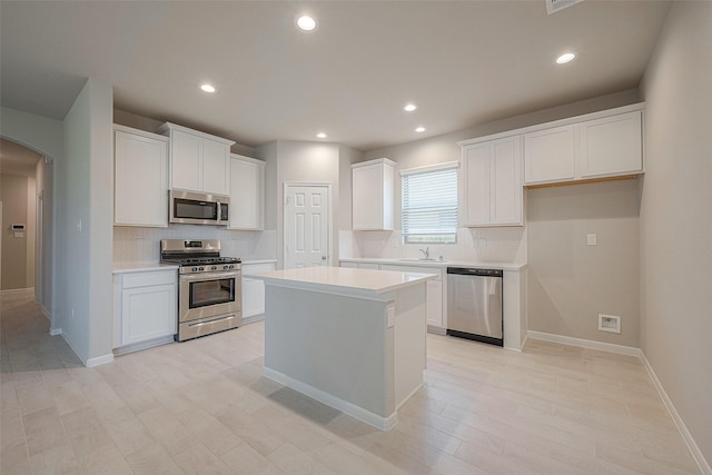 kitchen featuring sink, white cabinetry, tasteful backsplash, a center island, and appliances with stainless steel finishes