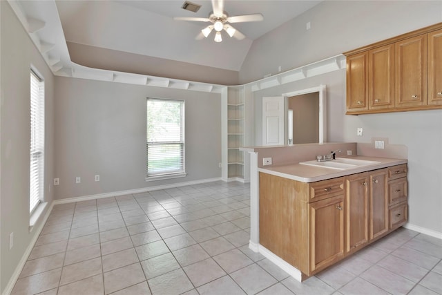 kitchen featuring sink, light tile patterned floors, vaulted ceiling, and ceiling fan