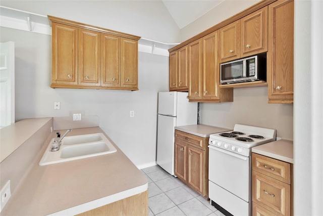 kitchen featuring vaulted ceiling, sink, light tile patterned flooring, and white appliances