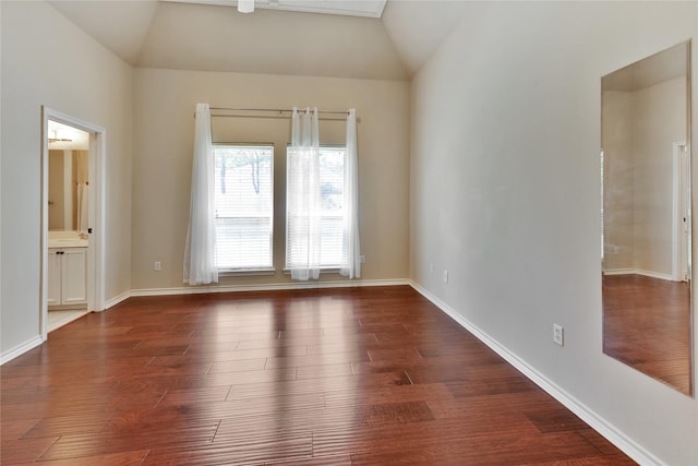 spare room with lofted ceiling and dark hardwood / wood-style flooring