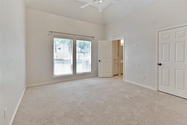 carpeted spare room featuring ceiling fan and a high ceiling