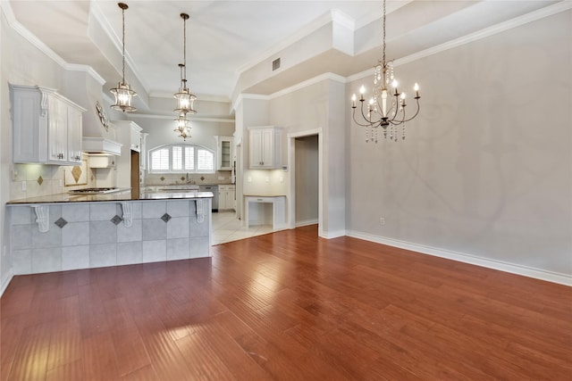 kitchen featuring light hardwood / wood-style flooring, white cabinets, backsplash, and decorative light fixtures