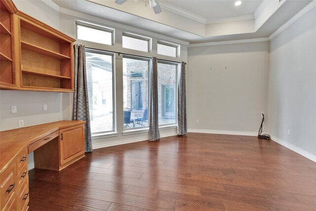 interior space featuring ornamental molding, dark wood-type flooring, a wealth of natural light, and a tray ceiling