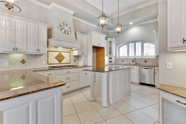 kitchen with stainless steel appliances, a kitchen island, and white cabinets