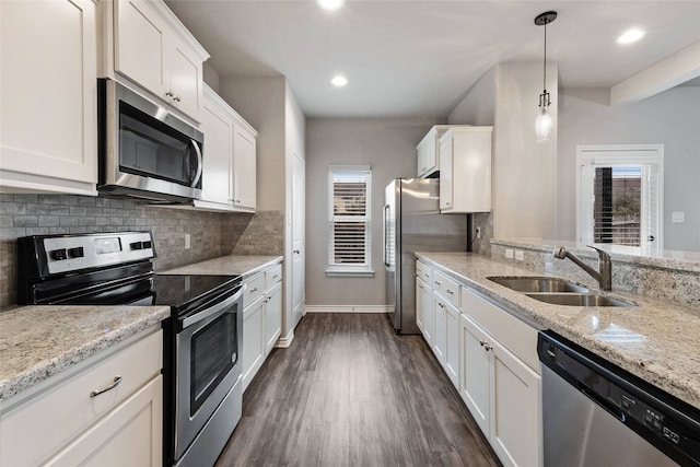 kitchen with white cabinetry, stainless steel appliances, sink, and pendant lighting