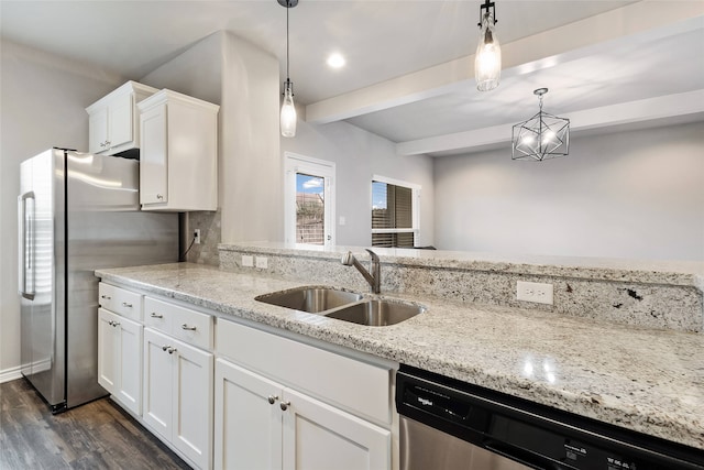 kitchen with pendant lighting, appliances with stainless steel finishes, sink, and white cabinets