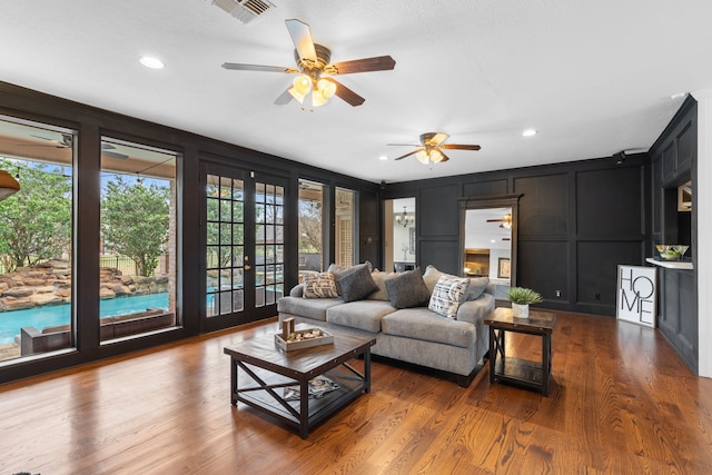 living room with hardwood / wood-style flooring, ceiling fan, and french doors