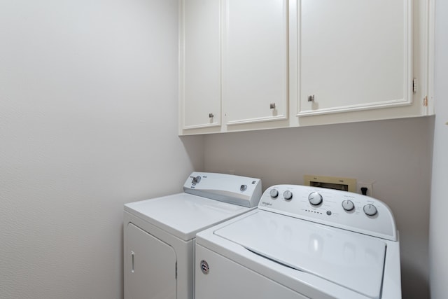 washroom featuring cabinets and washing machine and dryer