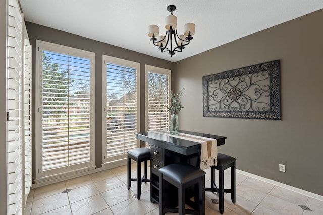 dining area with light tile patterned floors and an inviting chandelier