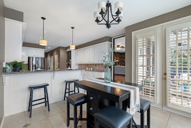 kitchen with stainless steel appliances, hanging light fixtures, white cabinets, and kitchen peninsula