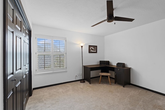 carpeted office space with ceiling fan and a textured ceiling