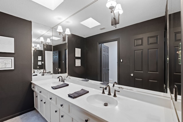 bathroom featuring vanity, a skylight, and toilet