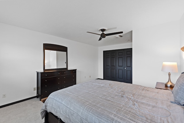 carpeted bedroom featuring ceiling fan and a closet