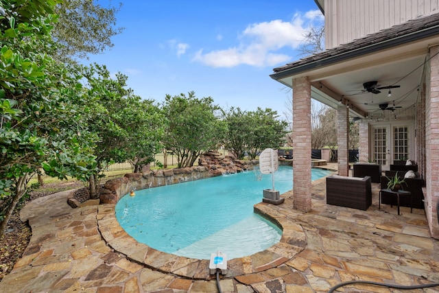 view of swimming pool with an outdoor living space, pool water feature, a patio, and ceiling fan