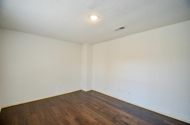 unfurnished room featuring dark hardwood / wood-style floors and a textured ceiling