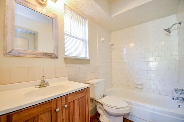 full bathroom featuring vanity, toilet, and tiled shower / bath combo