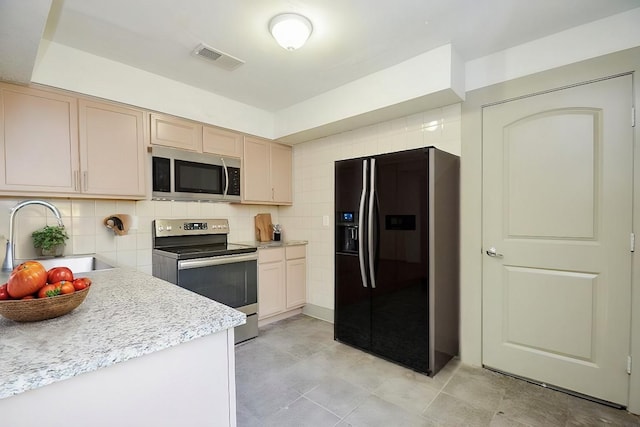 kitchen with light brown cabinetry, sink, backsplash, and appliances with stainless steel finishes