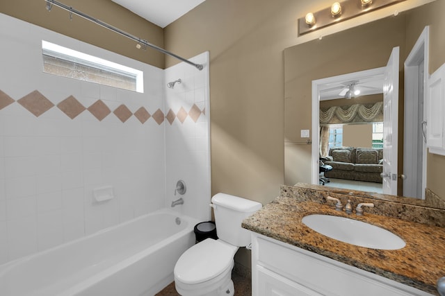 full bathroom with tiled shower / bath, plenty of natural light, toilet, and vanity