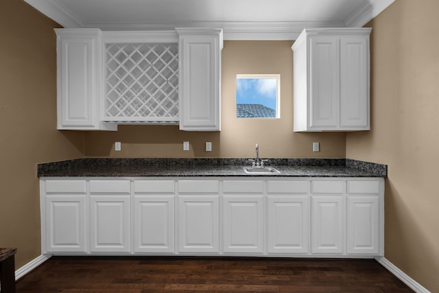 kitchen with crown molding, dark wood-type flooring, sink, and white cabinets