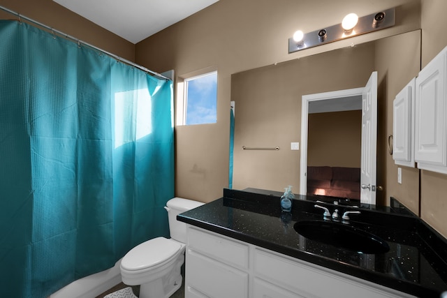 bathroom featuring vanity, walk in shower, and toilet