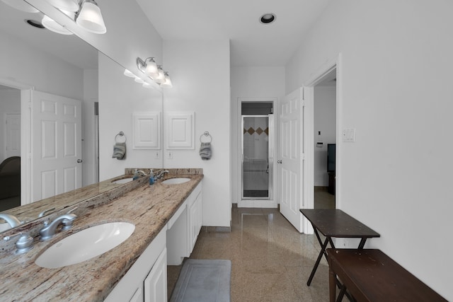 bathroom with vanity and a shower with door