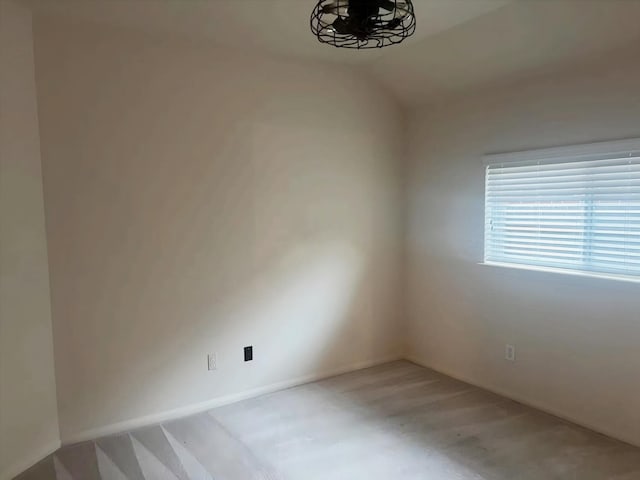 empty room with lofted ceiling and concrete floors