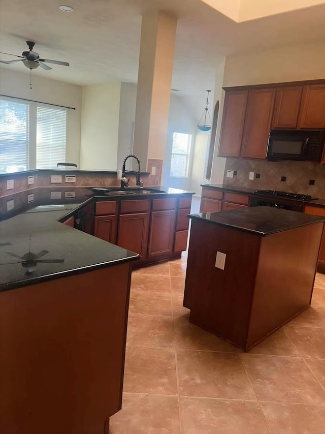 kitchen with tasteful backsplash, a healthy amount of sunlight, a kitchen island, and sink