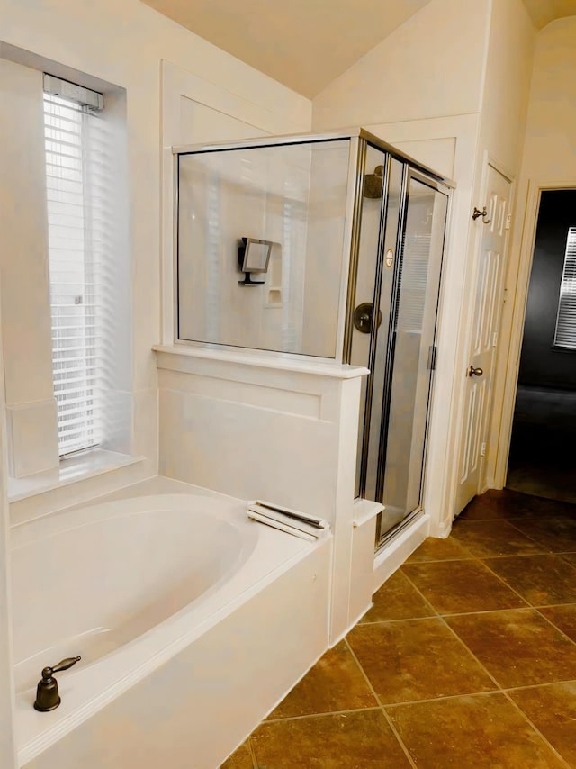 bathroom featuring lofted ceiling, shower with separate bathtub, and tile patterned flooring