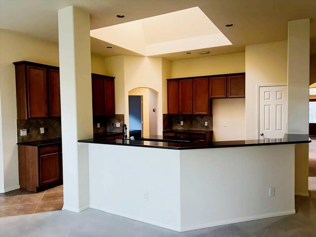 kitchen with sink, decorative backsplash, and kitchen peninsula