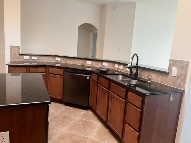 kitchen with sink, tasteful backsplash, light tile patterned floors, dishwasher, and dark stone counters