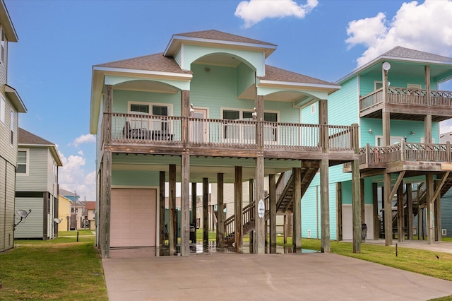 view of front facade with a carport, a garage, a porch, a balcony, and a front lawn