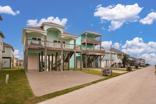 coastal home featuring a carport, a garage, a porch, and a front lawn