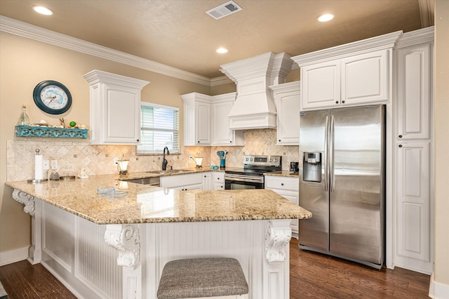 kitchen with a peninsula, white cabinetry, stainless steel appliances, and a sink